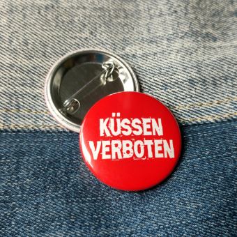 Ansteckbutton Küssen verboten auf Jeans mit Rückseite